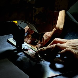Isson工場の職人がレザーアクセサリーを手縫いしている様子